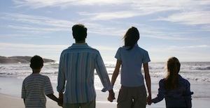 Young Couple with Two Children (8-12) Walking on the Beach