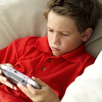 Young Boy (8-10) Sitting on a Couch Playing a Video Game