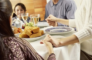 Portrait of a family saying grace before eating dinner