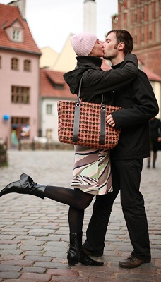 Young couple kissing in an old european town square.
