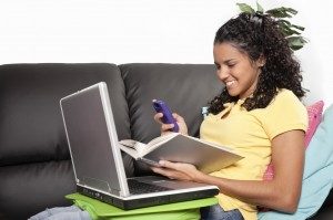 girl sitting on couch with books and phone