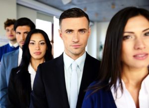 Group of a serious business people standing in a row in office