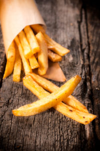 Selective focus on the front french fries on wooden table