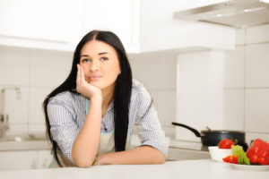 Beautiful woman thinking in kitchen