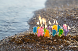 Birthday candles burning on a seashore