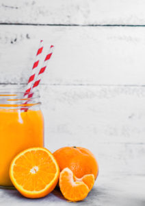 Orange smoothie on rustic background