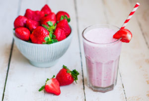 Strawberry milkshake on wooden background