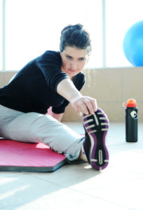 Fitness sporty girl with a ball at gym and bottle of water excercising