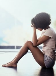 Shot of a young woman suffering from depression in her bedroom