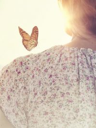 special moment of meeting between a butterfly and a girl in the middle of nature